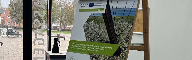 Plakat fra FEEL-projektet, der står på et staffeli