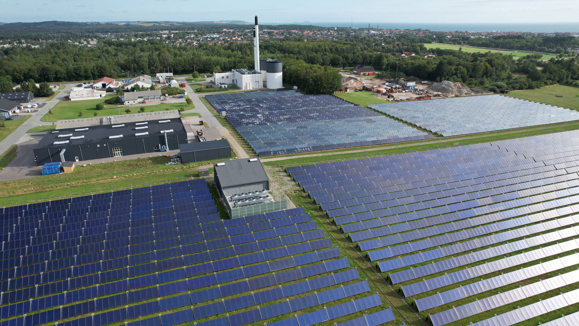 Dronebillede af Sæby Varmeværk med solcellepark foran